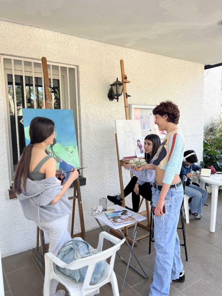 adolescentes pintando en la terraza de una escuela de arte