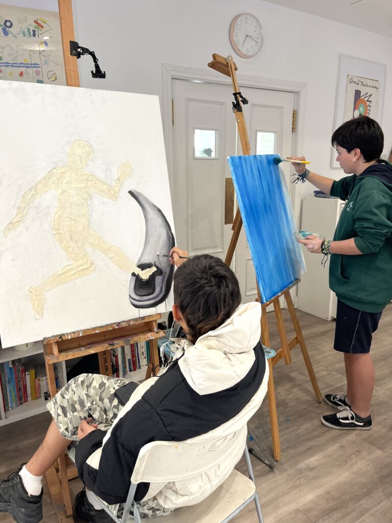 jovenes pintando en escuela de arte en espacio luminoso y grande