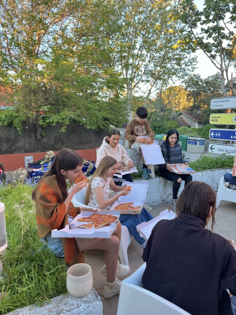 jovenes comiendo pizza en una escuela de arte
