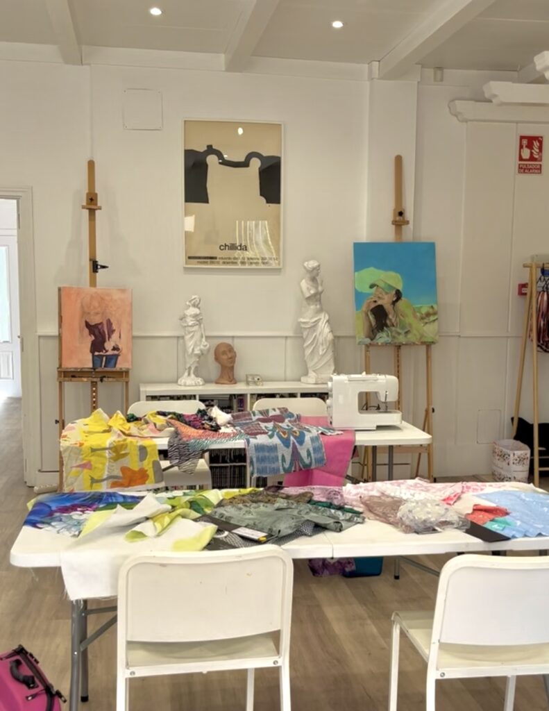 espacio donde se desarrollan los talleres de costura creativa en un ambiente muy bonito y con mucha luminosidad, donde se ven las máquinas de coser y telas