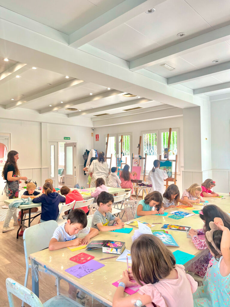 Niños y niñas pintando en la Escuela de Arte Espacio para el Arte en Torrelodones con muchos colores y materiales.